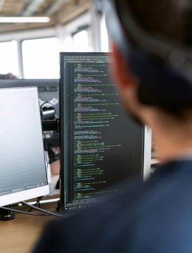 man in black shirt sitting in front of computer monitor